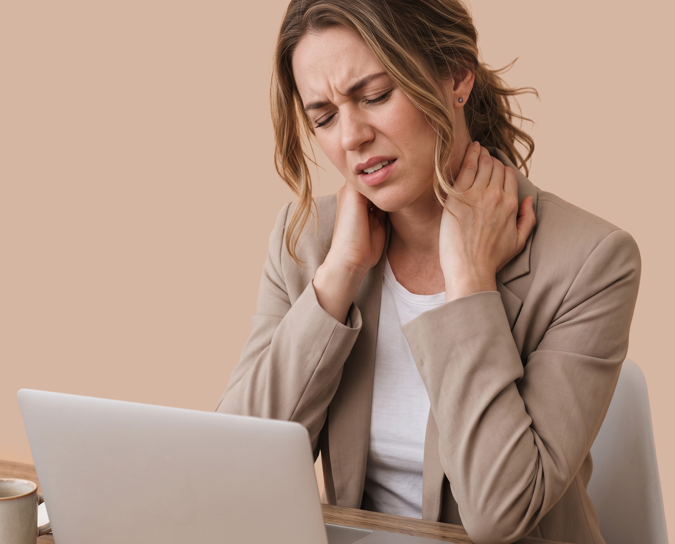 Desk worker sitting at a laptop and holding her neck after long hours of sitting